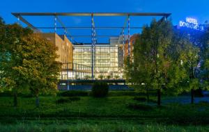 - une vue sur un bâtiment avec des arbres au premier plan dans l'établissement Trans World Hotel Donauwelle, à Linz