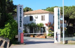 un panneau devant un bâtiment avec une maison dans l'établissement Résidence Tramariccia, à Calvi