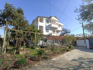 都拉斯Villa Osmani的前面有花园的白色建筑