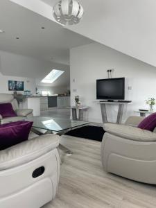 a living room with white furniture and a glass table at Lough Key Luxury Riverfront Apartment in Cootehall