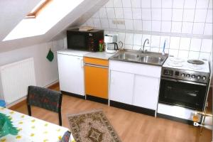 a small kitchen with a sink and a microwave at Ferienwohnungen Frohberg in Schneverdingen