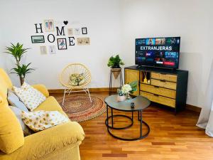 a living room with a yellow couch and a tv at Combarro Suite in Combarro