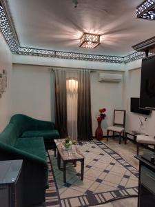 Shabana House في دهب: غرفة معيشة مع أريكة خضراء وتلفزيون