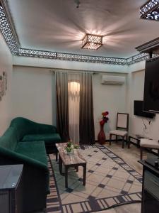 a living room with a green couch and a tv at Shabana House in Dahab