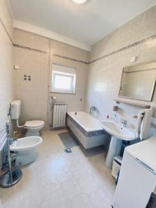 a bathroom with two toilets and a tub and a sink at Villa Nina Poreč in Poreč