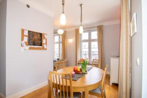 a kitchen and dining room with a wooden table and chairs at Maya's Flats & Resorts - Staromiejski Apartments in Gdańsk