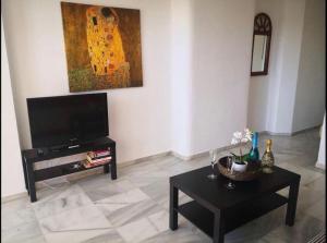 a living room with a flat screen tv and a table at Club Atlantis studio 160 - Playa de Las Americas in Adeje