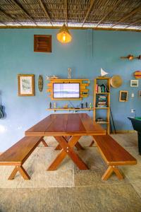 a wooden table in a room with a blue wall at Casa Mar Taíba in São Gonçalo do Amarante