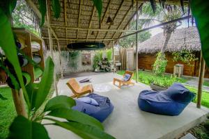 a patio with blue bean bags and a house at Casa Mar Taíba in São Gonçalo do Amarante