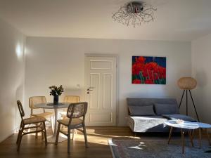 Apartment Hohe Pappel Weimar في فايمار: غرفة معيشة مع أريكة وطاولة وكراسي