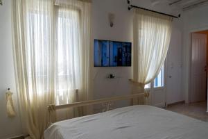 a bedroom with a bed and two large windows at Evilou's House in Krotiri