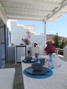 a white table with plates and bowls on top of it at Evilou's House in Krotiri
