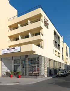 a large white building with a parking lot at Airotel Patras Smart Hotel in Patra