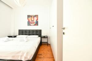 - une chambre avec un lit et une peinture murale dans l'établissement Thessaloniki City Apartment Center, à Thessalonique