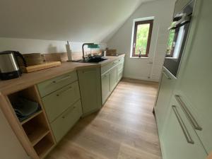 cocina con armarios blancos y suelo de madera en Apartment Hohe Pappel Weimar en Weimar