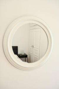 - un miroir rond dans une pièce blanche avec une table dans l'établissement Thessaloniki City Apartment Center, à Thessalonique