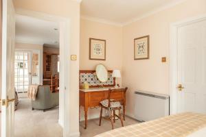 een slaapkamer met een kaptafel en een spiegel bij Balnagown Estates Peat Cottage in Kildary