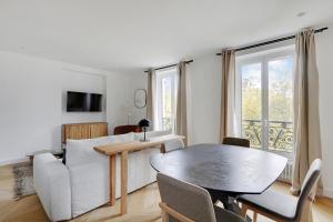 een woonkamer met een tafel en een bank bij Pick A Flat's Apartment on Place du Tertre in Parijs