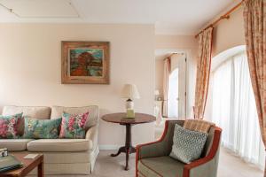 een woonkamer met een bank en een tafel bij Balnagown Estates Peat Cottage in Kildary