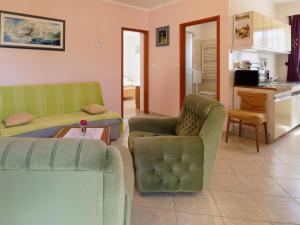 ein Wohnzimmer mit 2 Sofas und einer Küche in der Unterkunft Apartment Laganis in Plovanija