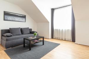 een woonkamer met een bank en een tafel bij Apartment Mariahilfer Strasse in Wenen