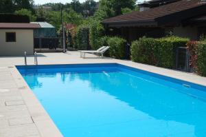 a blue swimming pool with a chair in a yard at Villino Vacanze "Il Porticciolo" in Manerba del Garda