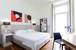ナポリにあるB&B Starbienの白いベッドルーム(白いベッド1台、デスク付)