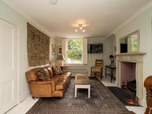 sala de estar con sofá de cuero y mesa en Pass the Keys Charming 3 bed townhouse next to Victoria Park, en Bath