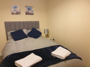 um quarto com uma cama com almofadas azuis e brancas em Cheerful 4 Bedroom Townhouse with free parking em Kenton