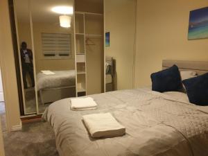 1 dormitorio con 1 cama con 2 toallas en Cheerful 4 Bedroom Townhouse with free parking, en Kenton