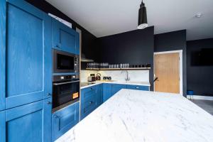 a kitchen with blue cabinets and a white counter top at Luxury Blackpool Apartments by Sasco in Blackpool