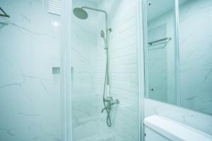 bagno con doccia e porta in vetro di The Garden Galleries Boutique Hotel a Pilar