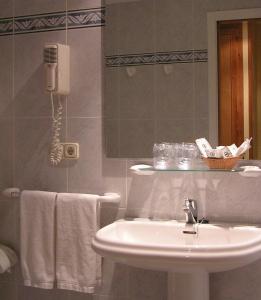 a bathroom with a sink and a phone on the wall at Hotel Isabel in Almussafes