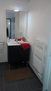 a bathroom with a white sink and a red towel at Résidence Néméa Caen Beaumois in Caen