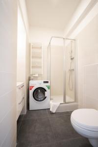 a bathroom with a washing machine and a toilet at Bright boutique apartment located 15 min from Stephansdom in Vienna