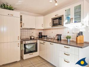 ケルピンセにあるInselhaus Whg 02の白いキッチン(白いキャビネット、電化製品付)