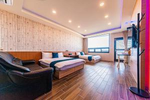 a bedroom with a bed and a couch and a chair at SUAo輕旅 in Suao