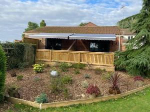 a garden in front of a house with a wooden fence at The Fuggle in Whaplode