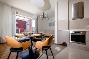 里沃的住宿－Resort Apartamenty Klifowa Rewal 79，厨房以及带桌椅的用餐室。