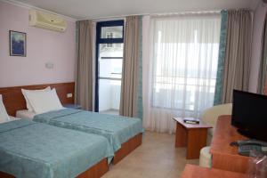 a hotel room with two beds and a television at Dunav Hotel in Sunny Beach