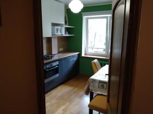 a kitchen with blue cabinets and a table and a window at Brivibas Avenue Apartment in Jūrmala
