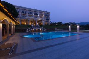 Montrose Golf Resort and Spa - Coorg في Jambur: حمام سباحة أمام مبنى