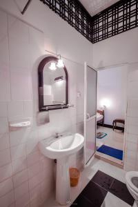 a white bathroom with a sink and a shower at Sea view Beach Resort in Unawatuna