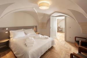 1 dormitorio con 1 cama blanca grande y techo abovedado en Palazzo dei Tolomei, en Lecce