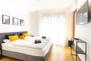 a bedroom with a large white bed with yellow pillows at Lahn-Living I - Gartenapartment - modern und hell in Lahnstein