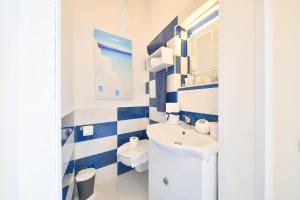 un bagno blu e bianco con lavandino e servizi igienici di Apartment Casa Suite Teresa , centro di Forio , Ischia a Ischia