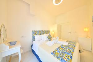 una camera bianca con un letto con un fiocco sopra di Apartment Casa Suite Teresa , centro di Forio , Ischia a Ischia
