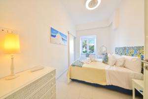 een witte slaapkamer met een bed en een raam bij Apartment Casa Suite Teresa , centro di Forio , Ischia in Ischia