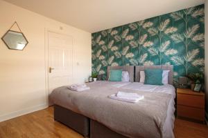 a bedroom with a large bed with towels on it at Modern & Contractors & City Centre & Parking in Lincolnshire