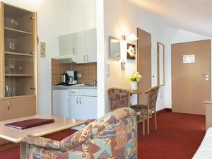 a kitchen and a living room with a table and chairs at Appartement-Hotel Sibyllenbad in Neualbenreuth